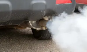 El tubo de escape de un coche emite una densa nube de humo blanco.