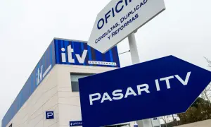 Edificio de ITV con señalización azul que indica "Pasar ITV". Si no pasas la ITV, podrías tener problemas.