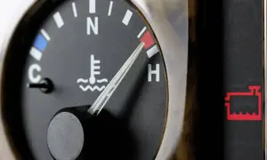 Indicador de temperatura del aceite del coche en rojo, cerca de "H". Alerta de batería encendida.