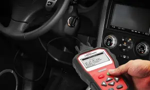 Mano usando un escáner obd coche para diagnosticar un problema. El dispositivo muestra códigos de error.