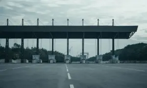 Peaje en España. Las motos también pagan peaje en esta autopista vacía, con grúas al fondo.