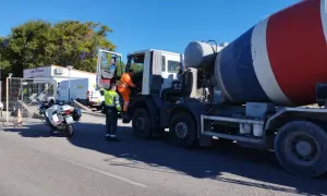 Agente de tráfico supervisa camión hormigonera en una estación de pesaje. La **itv en carretera** es crucial para la seguridad vial.