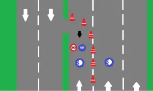 Conos rojos y señales de tráfico indican que es un carril especial. Flechas blancas marcan la dirección.
