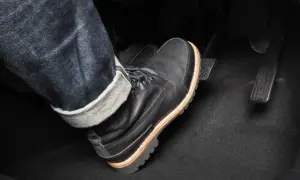 Pie con bota negra pisando el pedal del embrague. Para frenar hay que pisar el embrague y luego el freno.
