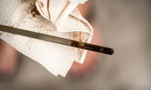 Medidor de aceite de coche con líquido oscuro, mostrando cómo se mira el aceite del coche.