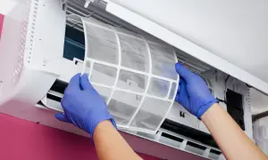 Manos con guantes azules sacan un filtro de aire de un aire acondicionado. Es hora de cambiar filtro aire acondicionado coche para un aire más puro.
