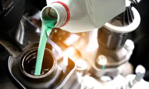 Vertiendo aceite 2T verde brillante en el motor de una motocicleta. El correcto porcentaje aceite 2t es crucial para el rendimiento.