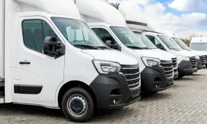 Flota de furgonetas blancas listas para su primera inspección técnica periódica.