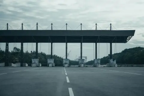 Peaje en España. Las motos también pagan peaje en esta autopista vacía, con grúas al fondo.