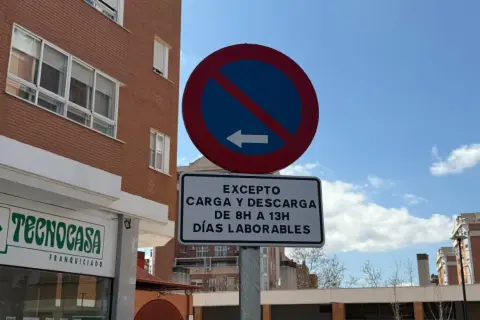 Señal de prohibido estacionar con excepción de carga y descarga de 8h a 13h en días laborables.