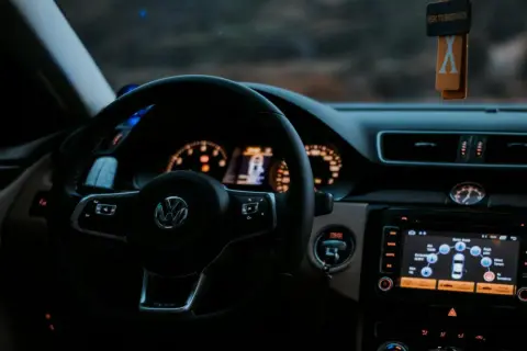 Volante de Volkswagen con sistema auto hold activado. El tablero muestra información del vehículo y el navegador.