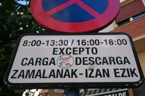 Señal de prohibido estacionar, excepto zona de carga y descarga en horarios específicos.