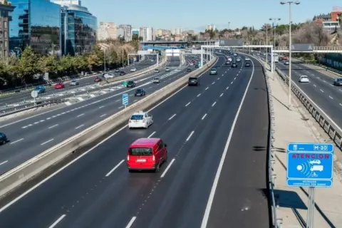 Vehículo con denegatoria que es: una furgoneta roja en autopista M-30, con señal de radar.