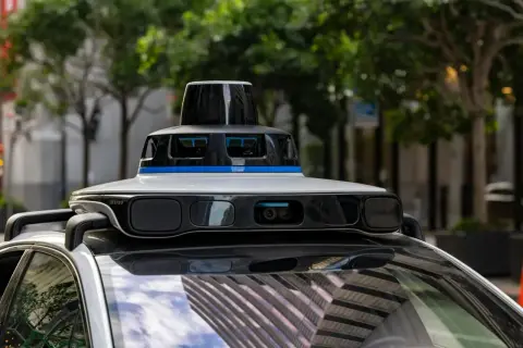 Un coche autónomo con sensores avanzados en su techo, listo para navegar por la ciudad.