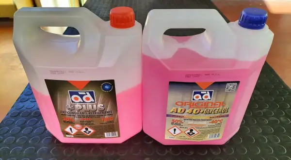 Dos garrafas de anticongelante rosa. Una es "AD PLUS" y la otra "AD ORIGINAL AD40+GLYCEROL". Ambas indican qué anticongelante lleva mi coche.