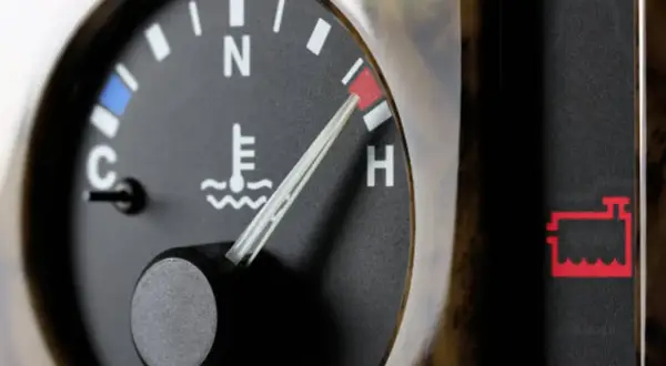 Indicador de temperatura del aceite del coche en rojo, cerca de "H". Alerta de batería encendida.