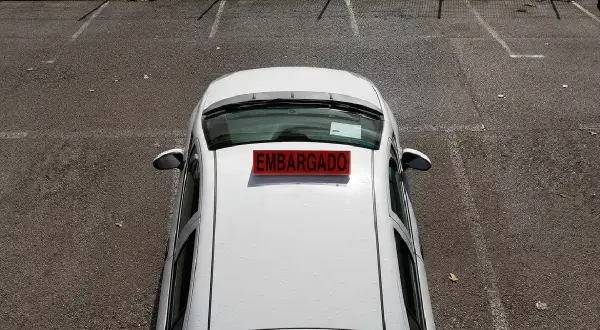 Un coche blanco con un letrero rojo de "EMBARGADO" en el techo. A pesar de estar embargado, ¿podría pasar la ITV?