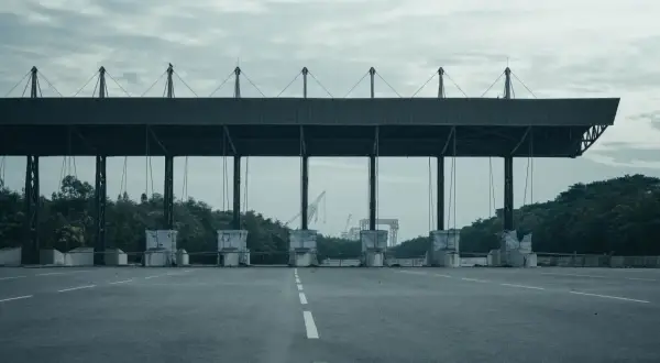 Peaje en España. Las motos también pagan peaje en esta autopista vacía, con grúas al fondo.
