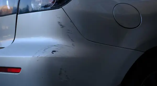 ¡Qué disgusto! Me han rayado el coche. Se ven marcas profundas en la defensa trasera y el lateral.