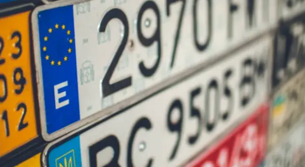 Varias nuevas matrículas de vehículos, algunas con el emblema de la UE y la letra "E", otras con números y letras.