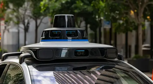 Un coche autónomo con sensores avanzados en su techo, listo para navegar por la ciudad.