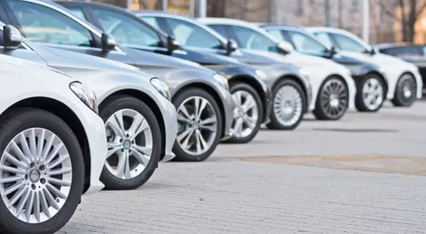 Una fila de coches modernos, mostrando diferentes tipos de aparcamiento y diseños de llantas.