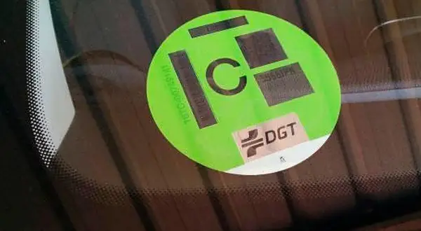Etiqueta DGT de distintivo ambiental C en parabrisas.