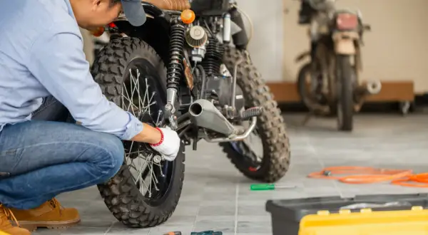 Mecánico revisa una moto. ¿itv motos cada cuanto? Pregunta clave para mantener tu vehículo en regla y seguro.