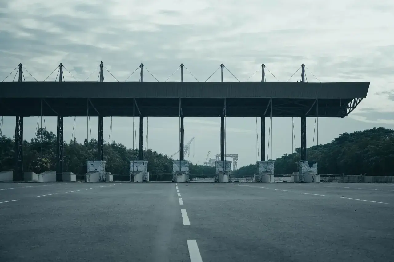 Peaje en España. Las motos también pagan peaje en esta autopista vacía, con grúas al fondo.