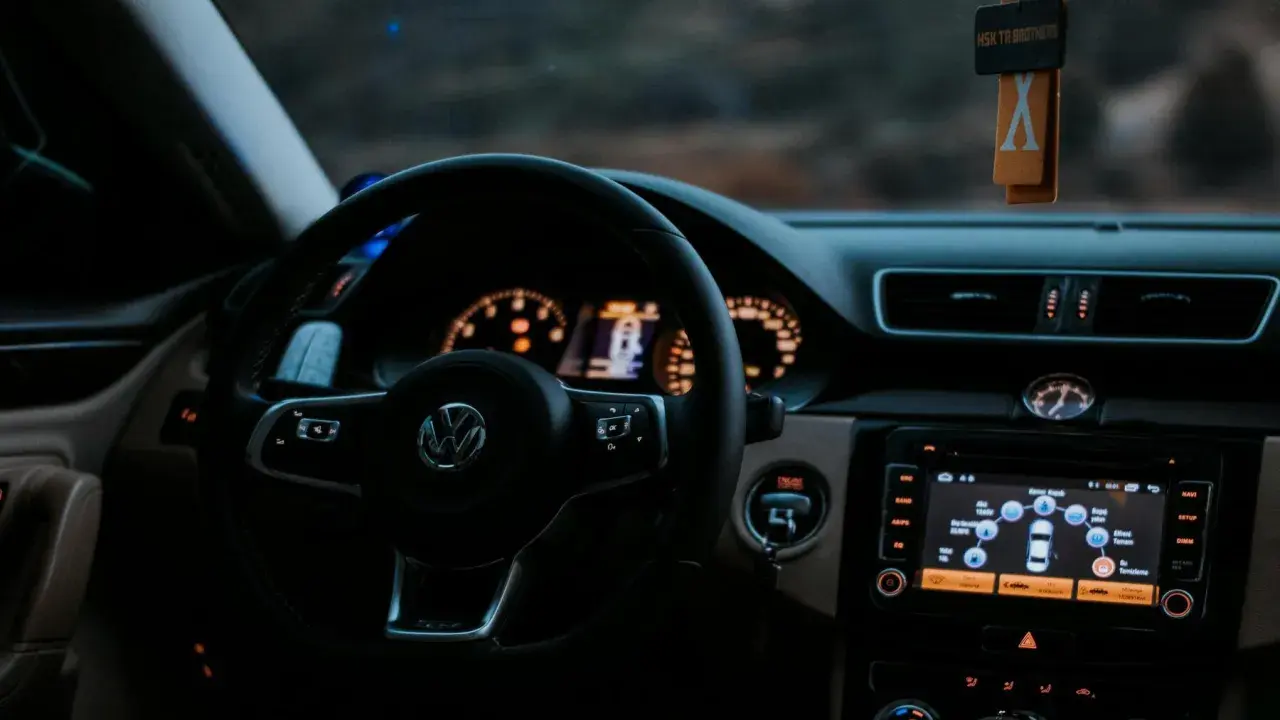 Volante de Volkswagen con sistema auto hold activado. El tablero muestra información del vehículo y el navegador.