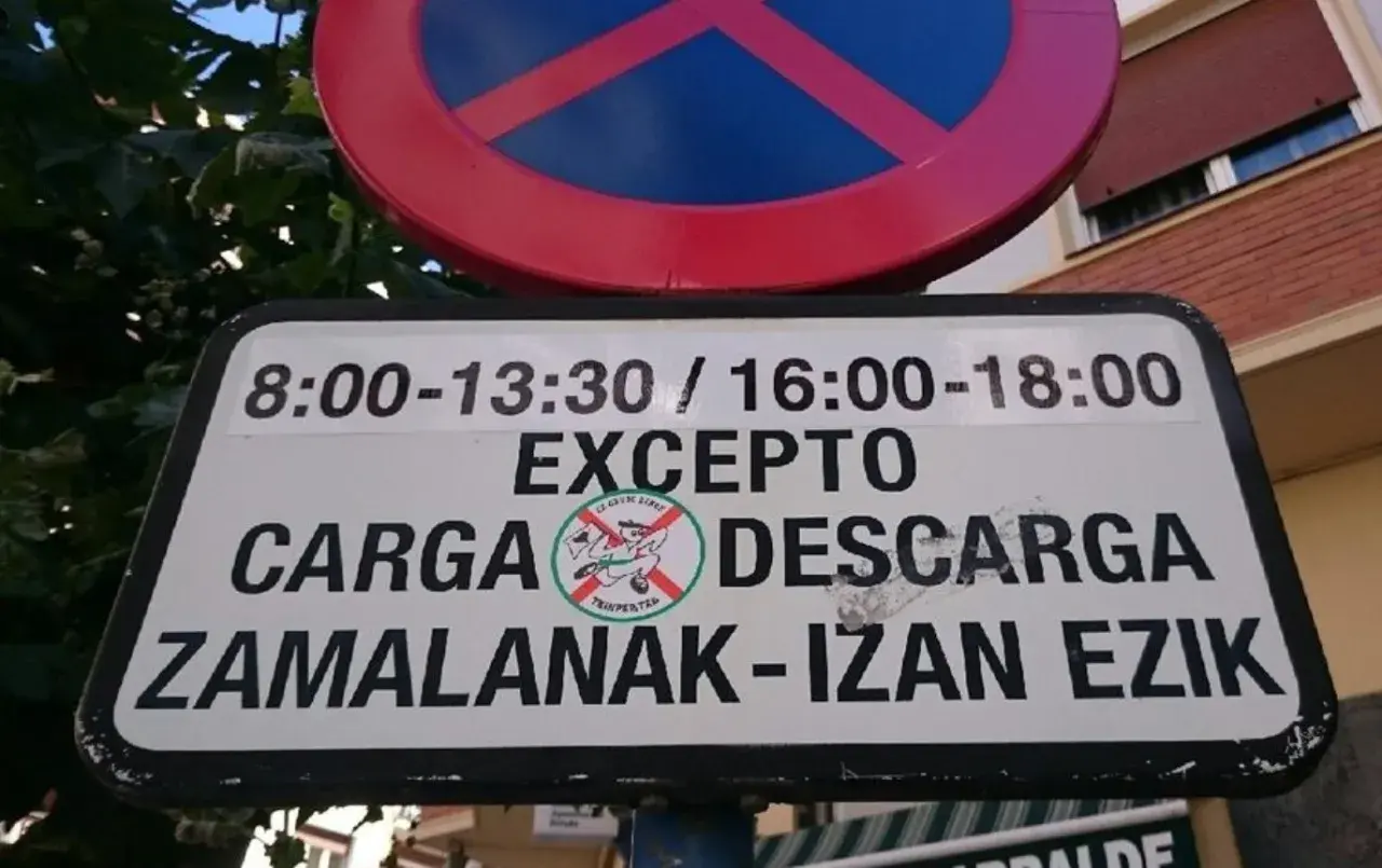 Señal de prohibido estacionar, excepto zona de carga y descarga en horarios específicos.