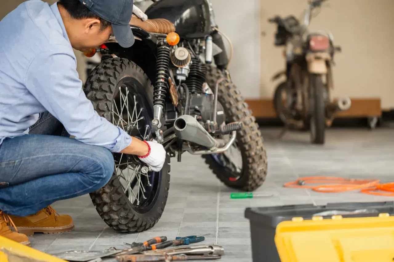 Mecánico revisa una moto. ¿itv motos cada cuanto? Pregunta clave para mantener tu vehículo en regla y seguro.