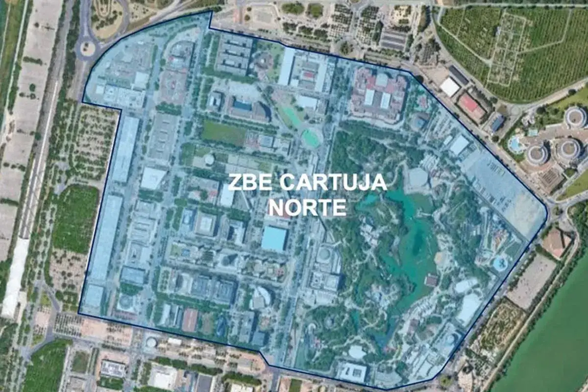 Vista aérea de la zona ZBE Cartuja Norte en Sevilla, mostrando edificios, áreas verdes y un cuerpo de agua.