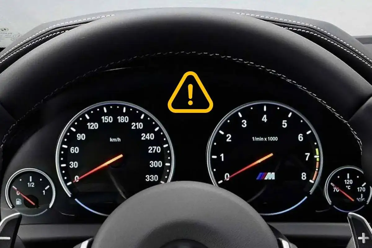 Panel de coche con velocímetro, tacómetro y un triángulo amarillo con un signo de exclamación, indicando que significa el signo de exclamación en el coche.