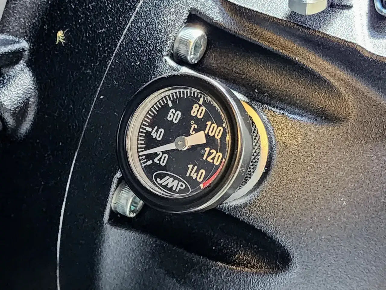 Medidor de temperatura del aceite coche, mostrando unos 40&deg;C. Un peque&ntilde;o insecto est&aacute; cerca.