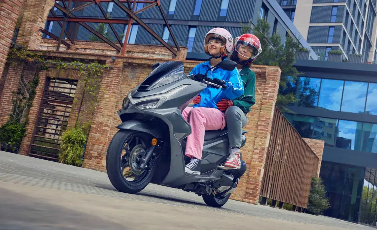 Dos jóvenes disfrutan de un paseo en moto. ¡Si te sacas el carnet de coche, puedes conducir moto!