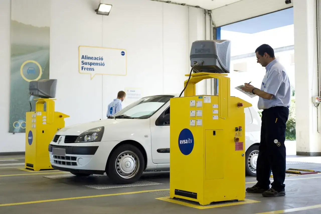 Técnico revisa coche en centro de inspección. El resultado de la itv desfavorable preocupa al conductor.