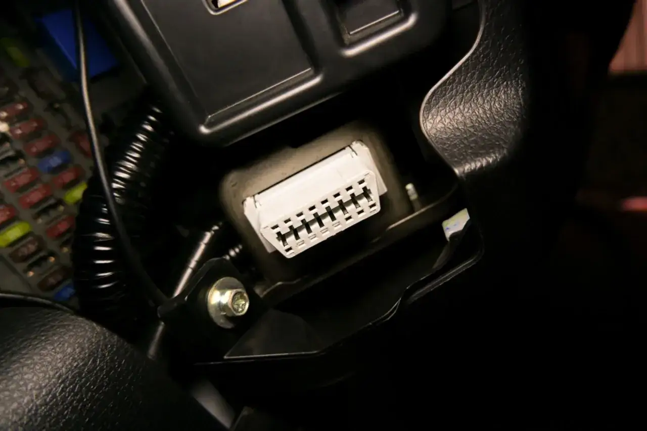 Conector obd coche listo para diagn&oacute;stico. A su lado, una fila de fusibles de colores.