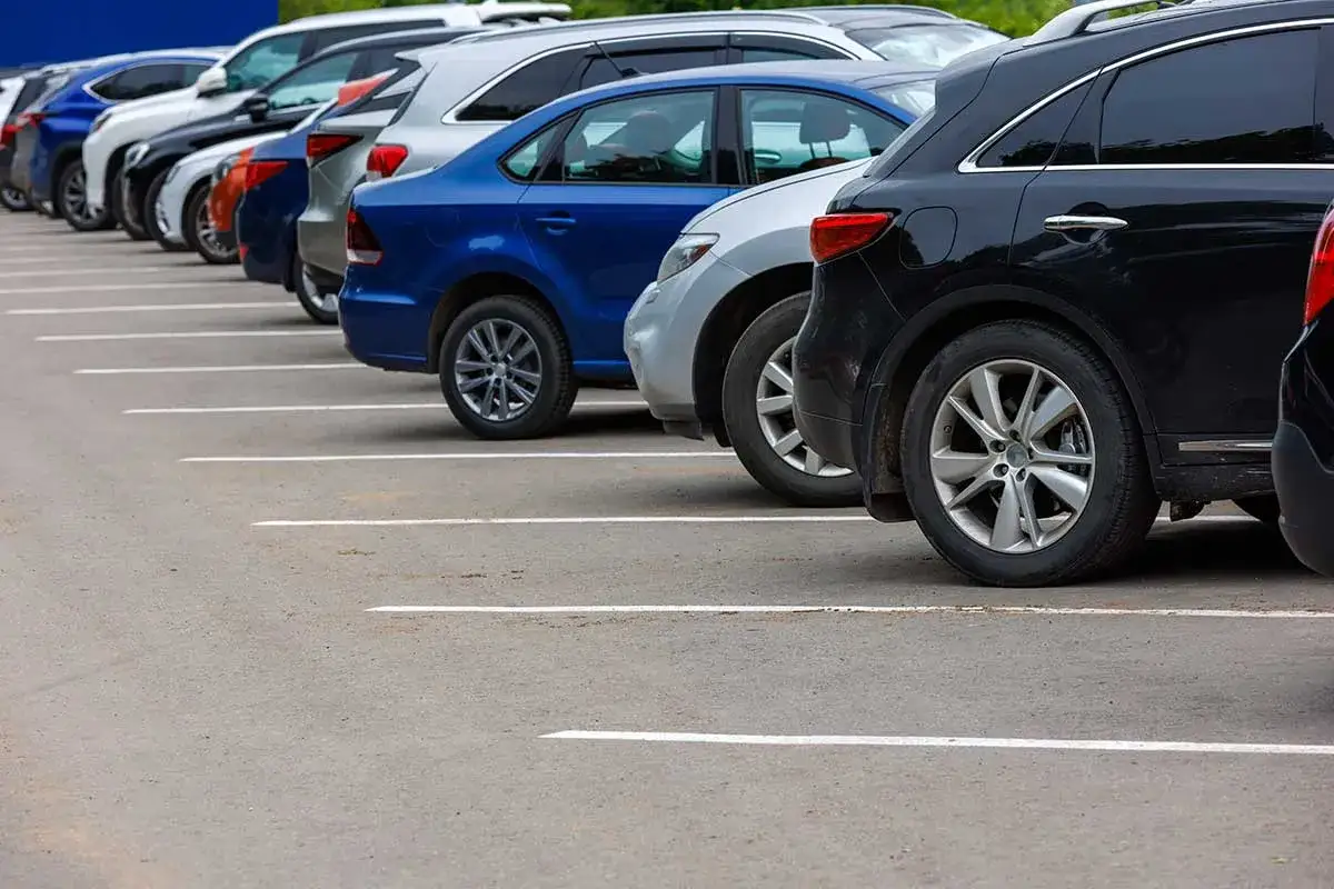 Varios coches de distintos tipos de aparcamiento, alineados en un estacionamiento.