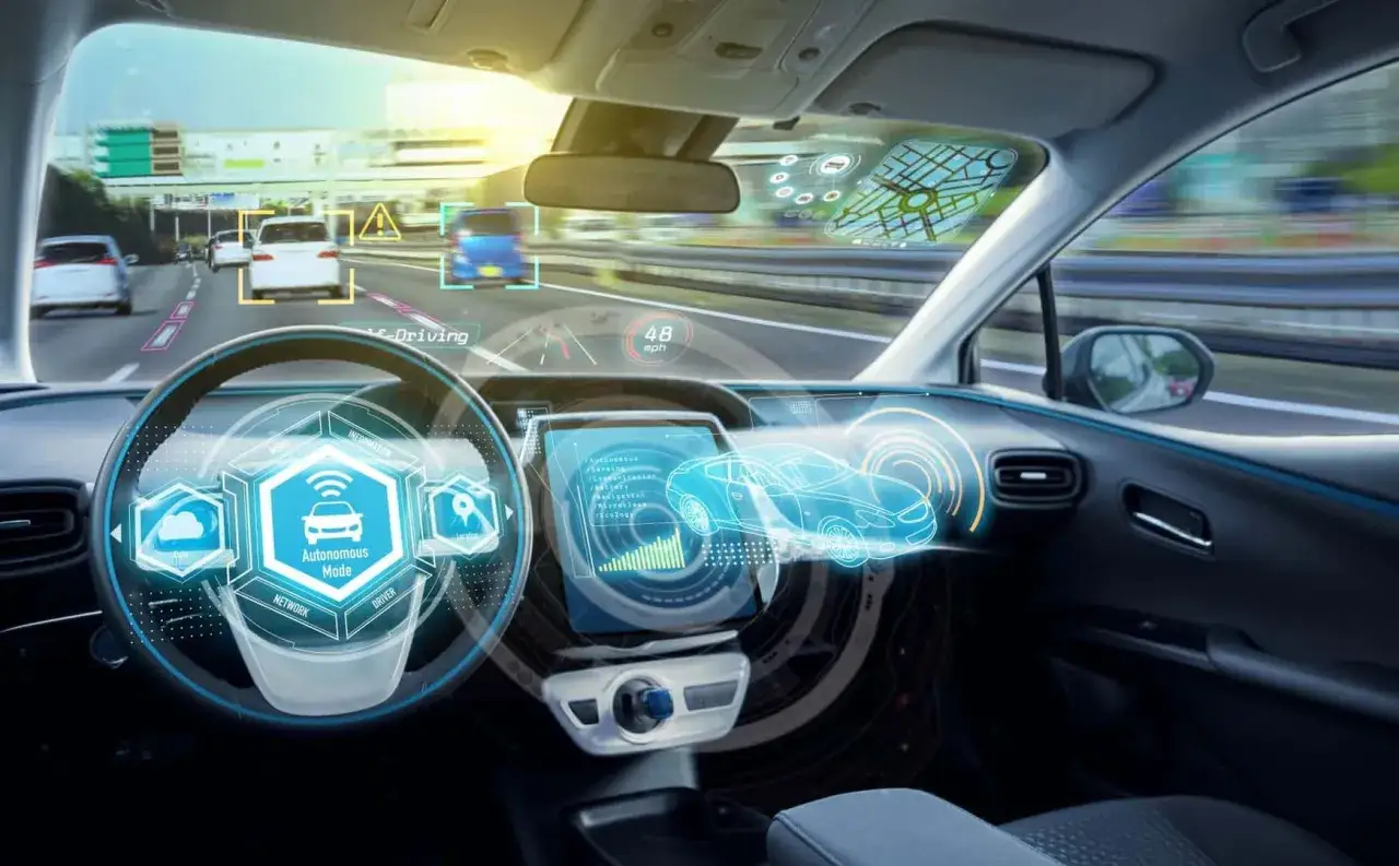 Interior de un coche con interfaz futurista mostrando c&oacute;mo conducir un coche autom&aacute;tico. El volante tiene un icono de coche aut&oacute;nomo.