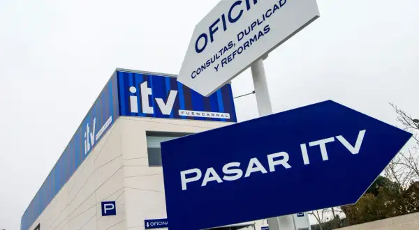 Edificio de ITV con señalización azul que indica "Pasar ITV". Si no pasas la ITV, podrías tener problemas.