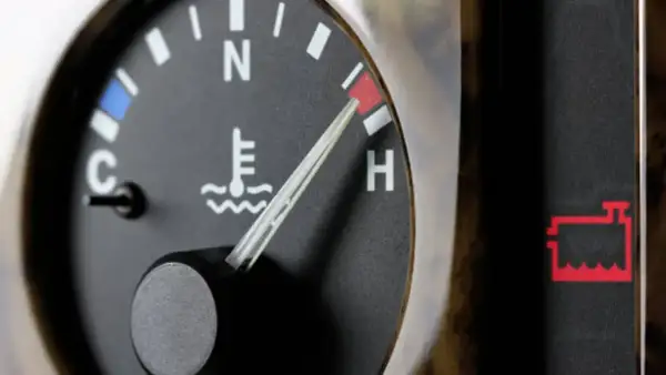 Indicador de temperatura del aceite del coche en rojo, cerca de "H". Alerta de batería encendida.