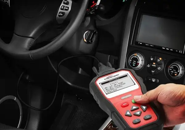 Mano usando un escáner obd coche para diagnosticar un problema. El dispositivo muestra códigos de error.