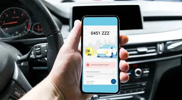 Mano revisa en el móvil que el coche 0451 ZZZ no tiene seguro. Es importante fiva comprobar seguro.
