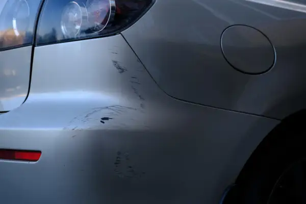 ¡Qué disgusto! Me han rayado el coche. Se ven marcas profundas en la defensa trasera y el lateral.