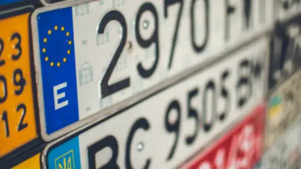 Varias nuevas matrículas de vehículos, algunas con el emblema de la UE y la letra "E", otras con números y letras.