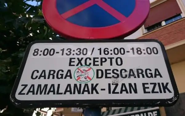 Señal de prohibido estacionar, excepto zona de carga y descarga en horarios específicos.