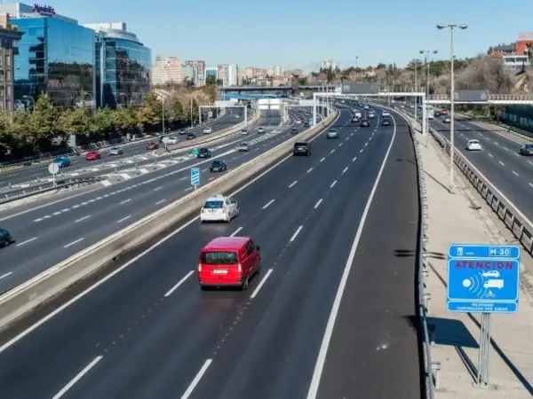 Vehículo con denegatoria que es: una furgoneta roja en autopista M-30, con señal de radar.