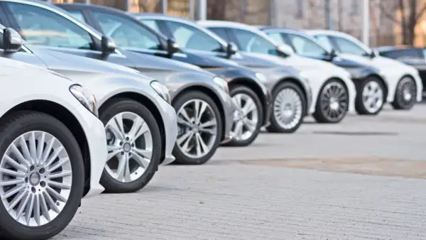 Una fila de coches modernos, mostrando diferentes tipos de aparcamiento y diseños de llantas.
